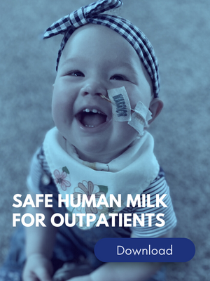 Infant with feeding tube in nose, sits and smiles at camera.
